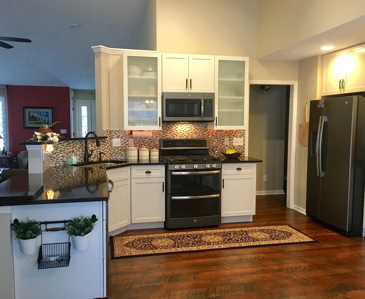 Modern kitchen with white cabinets and stainless steel appliances.